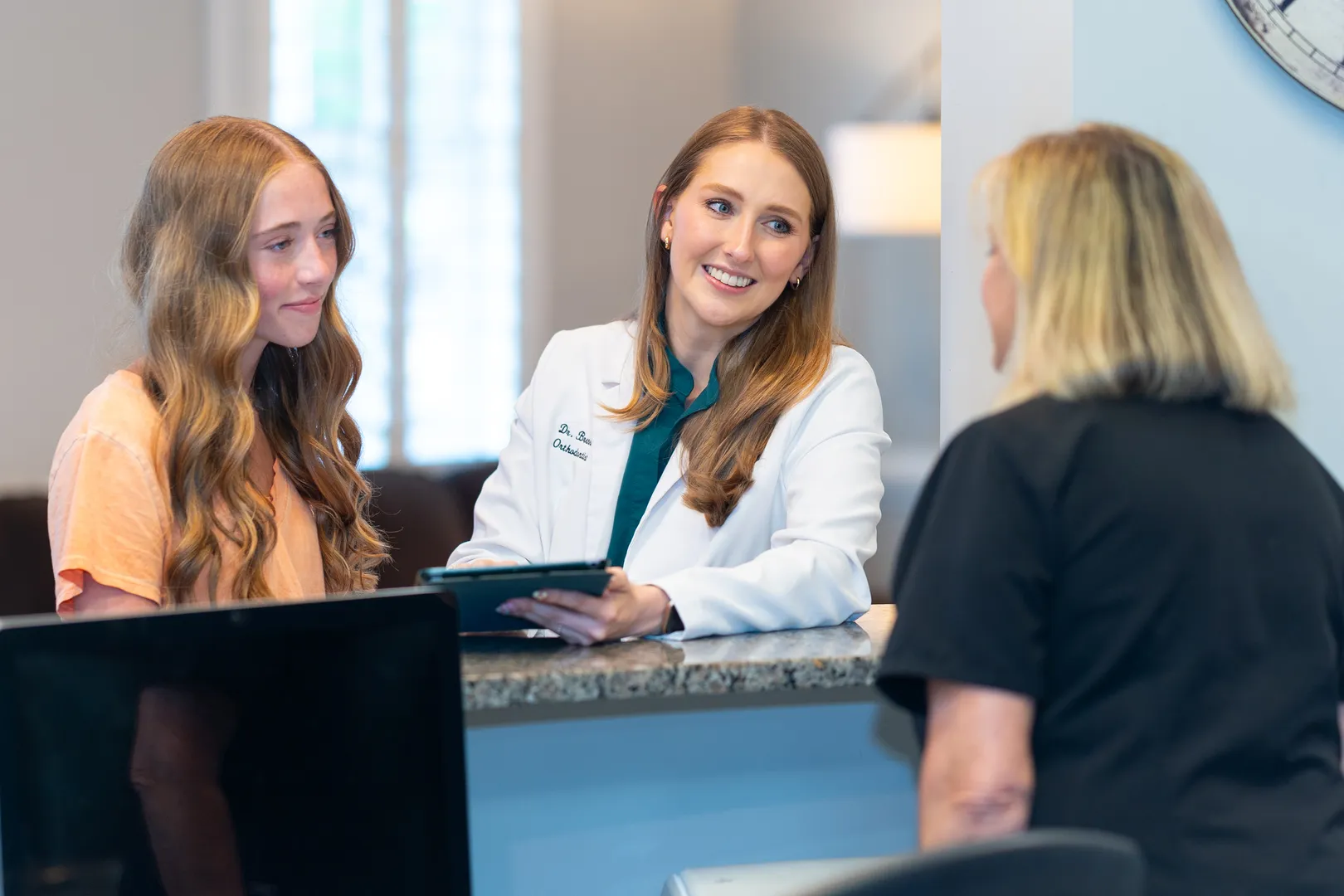 Dr. Brenna Reznik discussing treatment options at the reception desk at West Cobb Orthodontics