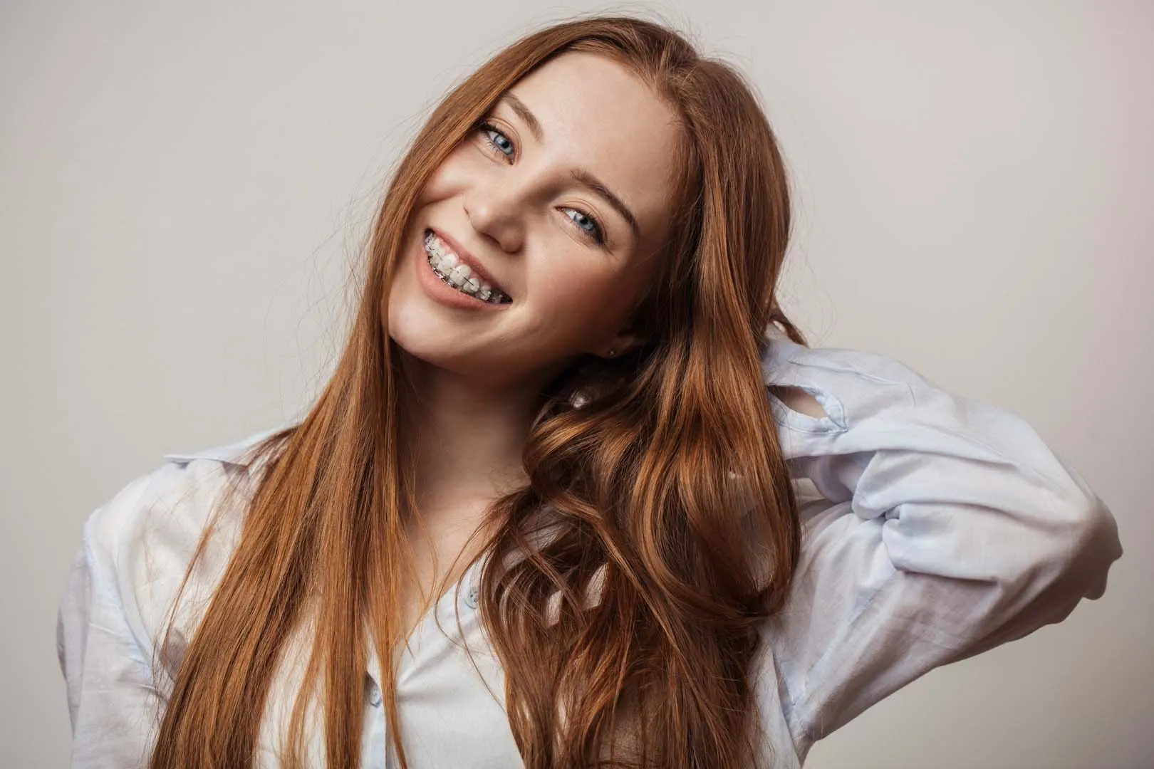Young woman with ceramic braces smiling confidently